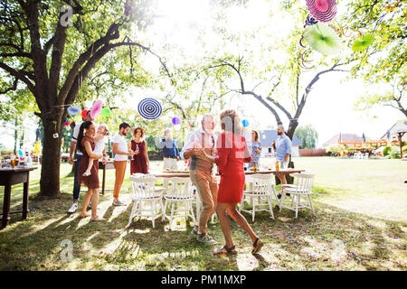 Un senior coppia danzante su un party in giardino al di fuori nel cortile. Foto Stock