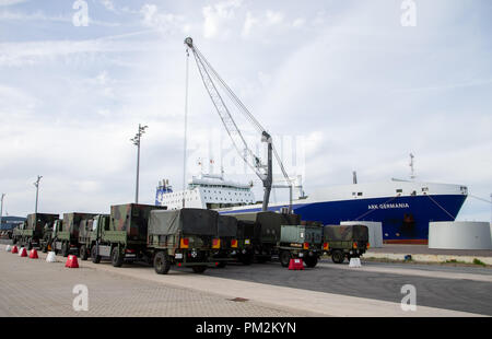 16 settembre 2018, Bassa Sassonia, Emden: Bundeswehr automezzi pronti per il caricamento nei locali di Emdem porto nella parte anteriore di una nave RoRo. L'esercitazione NATO "Trident frangente 2018 (TRJE 18)" si svolgerà in Norvegia dal 25 Ottobre al 7 novembre. La Bundeswehr è quello di trasferire quasi 10.000 soldati e più di 4.000 veicoli in Norvegia. Una nave viene caricata con circa 300 veicoli e cisterne nonché 95 container nel porto di Emden. Foto: Mohssen Assanimoghaddam/dpa Foto Stock