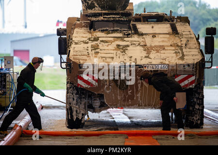 16 settembre 2018, Bassa Sassonia, Emden: Bundeswehr dipendenti pulizia di un blindato Bundeswehr del veicolo di trasporto, che è quello di essere caricato su una nave RoRo successivamente per motivi di Emden porto. L'esercitazione NATO "Trident frangente 2018 (TRJE 18)" si svolgerà in Norvegia dal 25 Ottobre al 7 novembre. La Bundeswehr è quello di trasferire quasi 10.000 soldati e più di 4.000 veicoli in Norvegia. Una nave viene caricata con circa 300 veicoli e cisterne nonché 95 container nel porto di Emden. Foto: Mohssen Assanimoghaddam/dpa Foto Stock