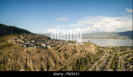 Antenna vista panoramica di case residenziali sulla cima di una montagna durante una vibrante sunny tramonto. Preso in Kelowna, BC, Canada Foto Stock