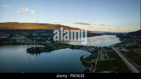 Antenna vista panoramica di una piccola cittadina, Oyama, durante una vibrante estate tramonto. Situato nei pressi di Kelowna e Vernon, BC, Canada. Foto Stock