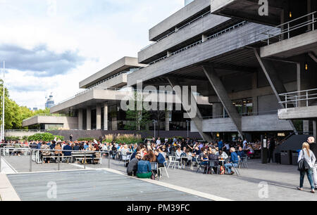 Persone di mangiare e di bere al di fuori del Royal National Theatre, South Bank, Inghilterra, Regno Unito. Foto Stock