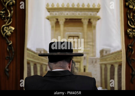 Un Ebreo adoratore pregando accanto alla Torah Arca armadio decorato con una figura che illustra il biblico tempio ebraico mentre si eseguono le Selichot o Slichot perdono rituale su Settembre 17, 2018 Il Selichot poesie penitenziale e le preghiere sono eseguite durante i dieci giorni di penitenza che precede il giorno dell'Espiazione, o Yom Kippur, il giorno più importante nel calendario ebraico, che nel 2018 inizia al tramonto su Settembre 18 all'interno di uomini della sezione di Wilson's Arch presso il Muro Occidentale composto nella città vecchia. Gerusalemme Est, Israele Foto Stock