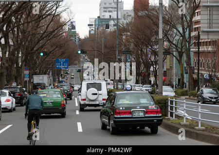 Vetture guida su strada di Omotesando, Tokyo, Giappone, Asia. Giapponese avenue con il traffico e gente che cammina Foto Stock