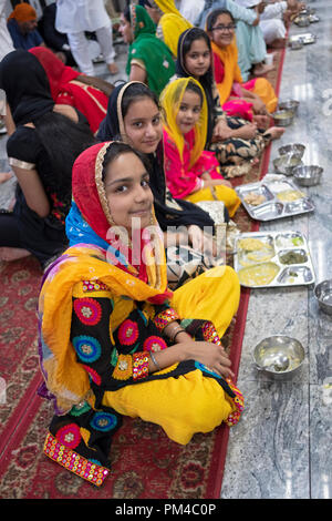 Gli adolescenti in un tempio sikh langar dove gratuitamente un pasto vegetariano è servita a chiunque senza eccezione. Foto Stock