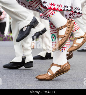 Ballerini bulgari in piedi in abiti tradizionali e scarpe ballo folk bulgaro ballare durante la Bulgaria Festival in Munakata, Fukuoka, Giappone 2018 Foto Stock