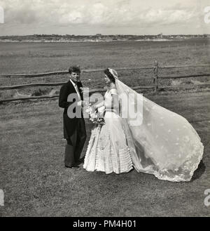 John Fitzgerald Kennedy e Jacqueline Bouvier Kennedy, in abiti da cerimonia, in piedi fuori sul giorno di nozze, 12 settembre 1953. Riferimento al file # 1003 156THA