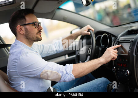 Uomo che utilizza il sistema di navigazione GPS in auto Foto Stock