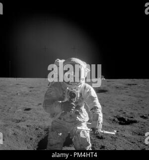 Astronauta Charles Conrad Jr., Apollo 12 commander, utilizzando un 70mm palmare fotocamera Haselblad modificati per superficie lunare utilizzo è fotografato il tentativo di scattare una foto della sua crewmate. Egli è anche in possesso di un tubo di nucleo. Il modulo lunare LM è nel lontano sullo sfondo. Immagine è stata presa durante la seconda EVA EVA2 dell'Apollo 12 missione. Pellicola originale magazine è stato etichettato X,tipo di pellicola era così-267 Plus-XX,alta velocità bianco e nero sottile pellicola di base,ASA 728 prese con un 60mm lente. Angolo di Sun è stata bassa. Approssimativo di inclinazione della telecamera era di medie obliqua e la direzione di inclinazione della telecamera è a sud ovest. (1969) il file no. Foto Stock