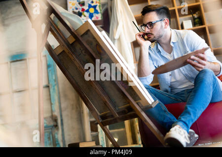 Ritratto di Artista maschile lavorando sulla pittura in Studio Foto Stock