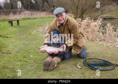 Tre anni di old boy e il nonno di Pesca a Mosca Report di Pesca alla trota Moorhen pesca, Warnford, Hampshire, Inghilterra, Regno Unito. Foto Stock