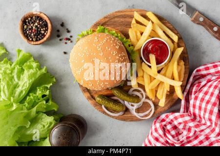 Gustosi hamburger e patatine fritte in legno che serve Board. Tabella vista superiore Foto Stock