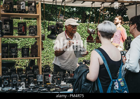 London, Regno Unito - 21 Luglio 2018: uomo vendita di fotocamere con pellicola in un mercato in stallo al Mercato di Portobello Road a Notting Hill, Londra. Portobello Road è il mondo del Foto Stock