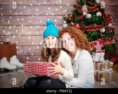 Due incantevoli bambine, suore con un regalo per l'anno nuovo nelle loro mani. Foto Stock