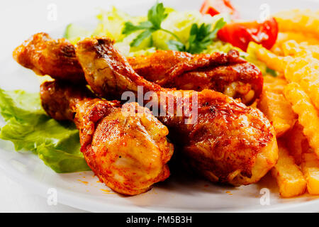 Pollo arrosto leags e patate con insalata sulla piastra bianca Foto Stock