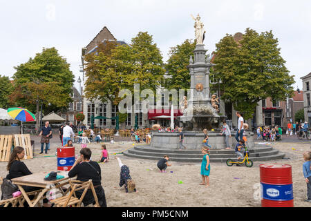 Bambini che giocano con la sabbia e acqua a sandbox improvvisata all interno della città Fontana di Deventer, Paesi Bassi Foto Stock