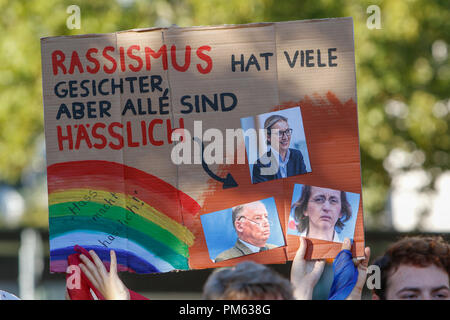 Bensheim, Germania. Xvi Sep, 2018. Un manifestante tiene un cartello che recita "Il razzismo ha molti faccia, ma tutti sono brutti' e le foto di leader politici AfD. Oltre un migliaio di persone provenienti da diversi partiti democratici e le organizzazioni hanno protestato in Bensheim in Assia contro la campagna di rally per il 2018 alle elezioni statali in Assia dall'estrema destra partito politico AfD (alternativa per la Germania). AfD vice leader del partito Beatrix von Storch è stato il principale oratore all'evento. Credito: Michael Debets/Pacific Press/Alamy Live News Foto Stock