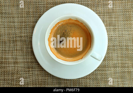 Vista dall'alto di una tazza di caffè caldo in tazza bianca servita a pranzo marrone Mat Foto Stock