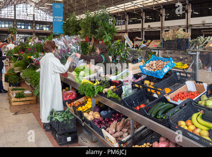 Donna l'acquisto di prodotti ad un mercato di frutta e verdura in stallo il Mercado da Ribeira, Lisbona, Portogallo Foto Stock