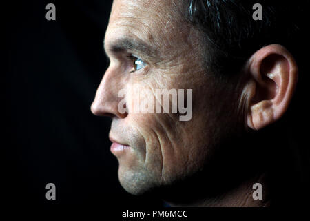 Ritratto di uomo su sfondo nero, di profilo Foto Stock