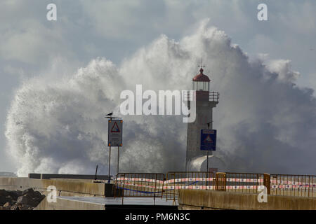 Tempesta di mare vicino al faro e Pier della foce del fiume con una barriera protettiva e cartelli di avvertimento di pericolo. Le luci di avvertimento pericolo dice: Atten Foto Stock