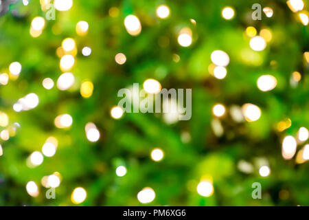 Sfocare lo sfondo con bokeh luci sul verde/closeup di offuscata albero di Natale con luci Foto Stock