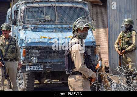 Poliziotti indiano guarda come egli sta di guardia durante le restrizioni su lunedì. Le autorità impongono delle restrizioni in più parti di Srinagar per prevenire le proteste chiamati dal Comune di Leadership di resistenza contro i recenti massacri civili nella valle del Kashmir. Foto Stock