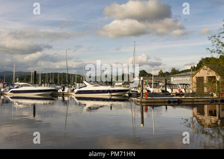 Due Fairline motor barche attraccate al molo della marina di Windermere Aquatic Ltd, con una barca a motore e yacht COMMERCIANTI, Bowness on Windermere, Cumbria. Foto Stock