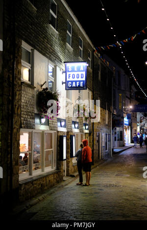 Un giovane guardando il menù al Sea Food Cafe su Fore Street in St Ives, Cornovaglia Foto Stock