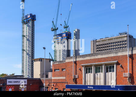 Anime e gru a torre di nuova utilizzazione mista a Victoria Square sviluppo sotto costruzione, un grande progetto di sviluppo in Woking town center visto dalla stazione in una giornata di sole Foto Stock