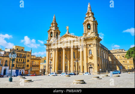 L'antica area Il-Fosos (granai) nella parte anteriore della magnifica St Publio chiesa con porticato neoclassico e alti campanili, Floriana, Malta. Foto Stock