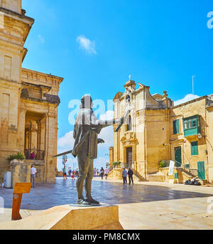 La Valletta, Malta - 17 giugno 2018: il monumento a Jean de la Valette, situato sulla piazza f il suo nome, con una vista sulla cappella di Nostra Signora delle Vittorie Foto Stock