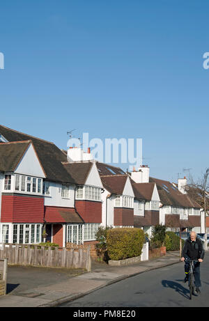 Edwardian semi-case unifamiliari in East Sheen, Londra, Inghilterra, con uomo anziano in sella a una moto Foto Stock