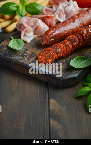 Il salame chorizo. Spagnolo tradizionale il salame chorizo con erbe fresche e pomodori. Foto Stock