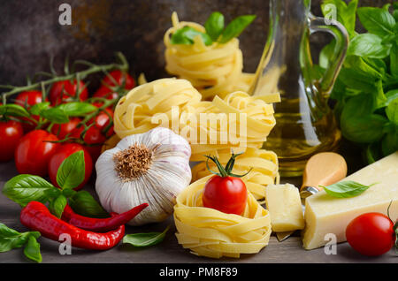 Pasta, verdure, erbe aromatiche e spezie per il cibo italiano sullo sfondo di legno, fuoco selettivo. Foto Stock