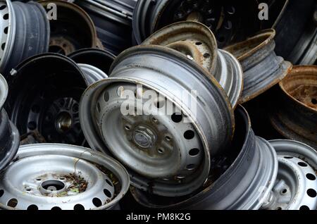 Un mucchio di vecchio metallo arrugginito cerchioni ruota in auto discarica per rifiuti del veicolo Foto Stock