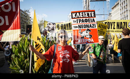 Una donna si vede in possesso di una bandiera e un poster durante la protesta. Migliaia protester ha preso le strade contro il fascismo e il razzismo in Atene. Il mese di marzo è stata principalmente focalizzata sull'assassinio del rapper Pavlos Fyssas, da una neo-nazista nella città di Pireo un paio di anni fa. Foto Stock