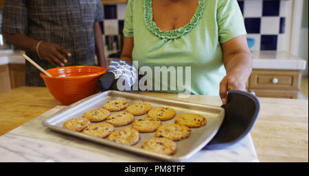 Senior donna nera con biscotti appena sfornati Foto Stock