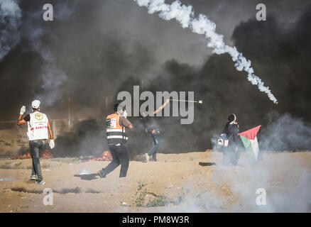 Un uomo palestinese visto utilizzando una fionda per lanciare sassi verso le forze israeliane durante gli scontri. Scontri tra dimostranti palestinesi e le forze israeliane durante una manifestazione di protesta lungo la recinzione israeliana a est di Gaza City. Foto Stock