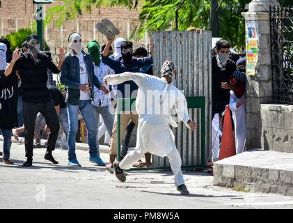 Un manifestante mascherato visto che lanciano pietre presso la polizia durante gli scontri. Scontri scoppiati tra contestatori del Kashmir indiano e le forze di governo subito dopo il venerdì le preghiere della congregazione si è conclusa nella grande moschea di Srinagar. Foto Stock