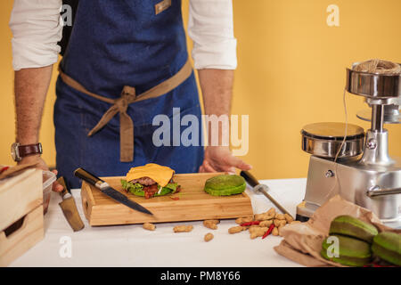 Lo Chef aggiunge il basilico su burger cucinare hamburger concept Foto Stock