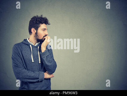 Preoccupato ansioso giovane il suo mordere le unghie Foto Stock