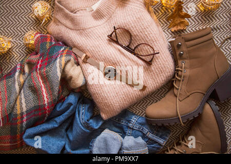 Autunno abbigliamento vestito con un maglione, jeans e stivali, vista dall'alto di autunno/inverno abito idea con gli occhiali e guardare accessorio Foto Stock