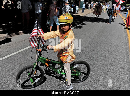 Vietnamese-American boy per la sua trazione a due ruote alla bicicletta con una bandiera americana sul suo manubrio prende parte alla 73Una Giornata Mondiale celebrazione in Cleveland Foto Stock