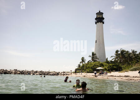 Persone in mare di fronte a Cape Florida luce, la più antica struttura permanente in Greater Miami, a Bill Baggs Cape Florida State Park Foto Stock