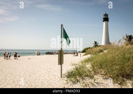 La gente camminare sulla spiaggia dominato dal Cape Florida luce, la più antica struttura permanente in Greater Miami, a Bill Baggs Cape Florida State Park Foto Stock