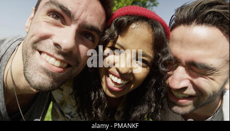 Primo piano di tre giovani amici multirazziale godendo il sole Foto Stock