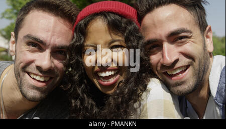 Primo piano di tre giovani amici multirazziale godendo il sole Foto Stock