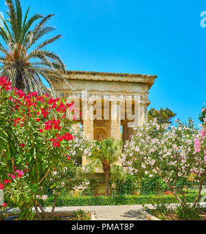 I greco-stile tempio-monumento dedicato a Sir Alexander Ball, è circondato da una vegetazione lussureggiante di Lower Barrakka Gardens con la fioritura di rododendro Foto Stock