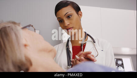 Attraente medico femmina femmina holding coppia mano del paziente Foto Stock